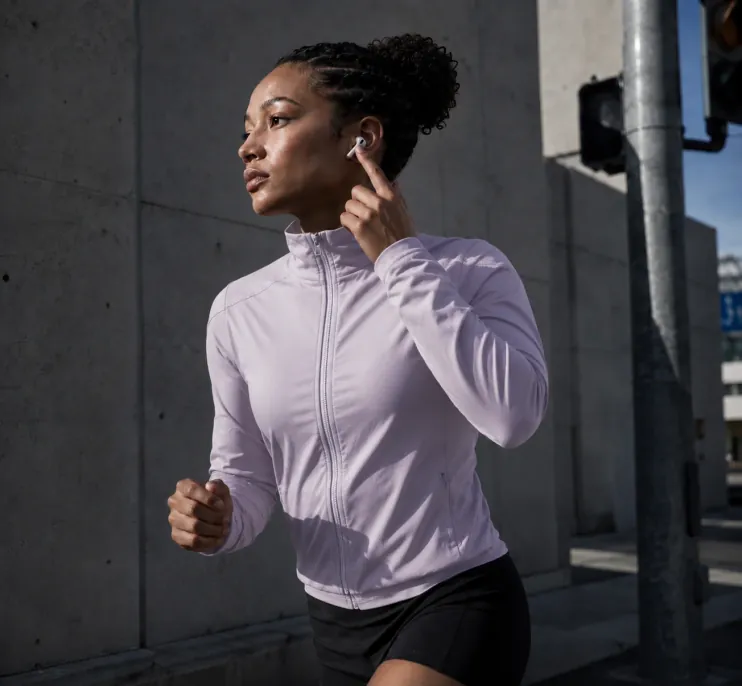 A runner double-tapping her AirPod to save a moment